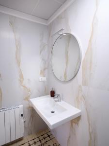 Un baño blanco con lavabo y espejo. en V11apartamentos1, en Archidona 11 fotos más