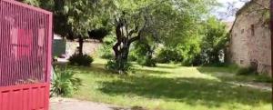 un cortile con un albero e una recinzione rossa di La Perseverancia a Aldehuela