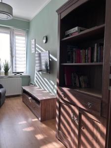una sala de estar con una estantería con libros en Apartament Ola, en Busko-Zdrój