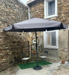 a blue umbrella sitting in front of a building at La Carmencita in Cedeira