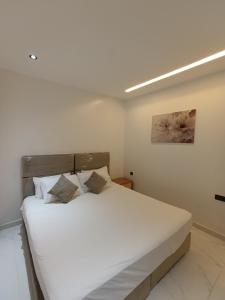 a bedroom with a large bed with white sheets at Appartement marhaba family only in Tangier