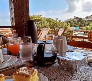 a table with a plate of cake and glasses of water at Casa Colomba in Búzios
