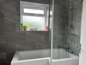 a bathroom with a bath tub and a window at Brithdir Cottage in Merthyr Tydfil
