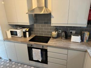 a kitchen with a counter top with a microwave at Brithdir Cottage in Merthyr Tydfil +15 photos