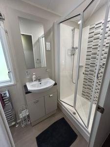 a bathroom with a glass shower and a sink at 23 larch view luxury caravan tattershall lakes in Tattershall +12 photos