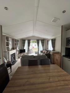 a living room with a table and a couch at 23 larch view luxury caravan tattershall lakes in Tattershall