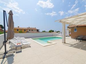 a villa with a swimming pool and a patio at Villa Matthias by Rent Istria in Ližnjan