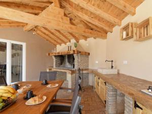 a kitchen with a wooden table and a fireplace at Villa Matthias by Rent Istria in Ližnjan