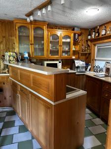 a large kitchen with wooden cabinets and a sink at Къща за гости Гаджакови in Devin
