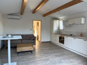 Una cocina y una sala de estar con un sofá y una mesa. en La campagne au bord de la mer, en Porto Vecchio