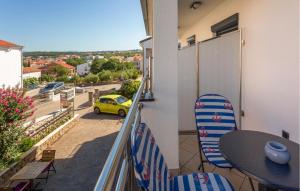 een balkon met een tafel en stoelen en een gele auto bij 1 Bedroom Nice Apartment In Bogovici in Malinska +18 foto's