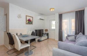 een woonkamer met een tafel en een bank bij 1 Bedroom Nice Apartment In Bogovici in Malinska