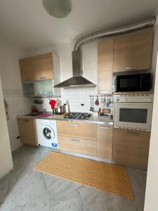 a kitchen with wooden cabinets and a stove top oven at Appartamento Malibù Miramare in Genoa