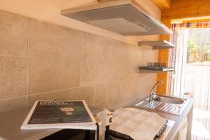 a kitchen with a sink and a book on a counter at Villa il Poderino in Marina di Campo