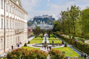 a view of a park with a fountain and buildings at Pension Jahn in Salzburg