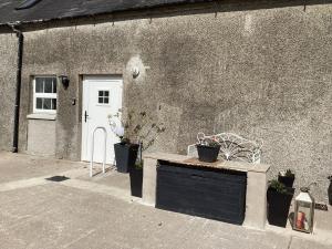 un edificio con una puerta negra y algunas macetas en Derrywilligan Guest Accommodation, en Bessbrook