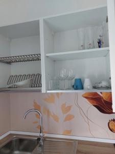 a kitchen with a sink and shelves with wine glasses at CasaMARina in Misano Adriatico