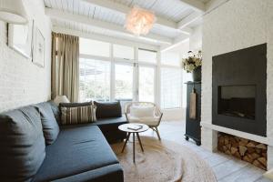a living room with a blue couch and a fireplace at Toekomst 27 - Ouddorp NOT INTENDED FOR COMPANY OR WORK-RELATED STAYS in Ouddorp