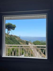 a window with a view of a hill with a tree at Afytos Dream suites sea view in Afitos