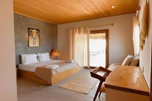 a bedroom with a bed and a large window at Casa Caju Tatajuba in Tatajuba