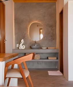 a bathroom with a mirror and a wooden chair at Casa Caju Tatajuba in Tatajuba