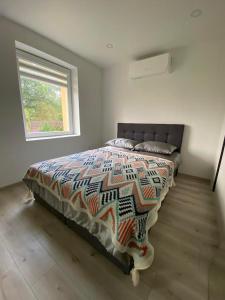 a bedroom with a bed with a comforter and a window at GreJoTa in Šilutė