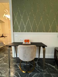 a black table with a chair and a wall at Lovely Rooms in La Spezia