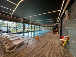 basen z szezlongami w budynku w obiekcie Kasprowicza 20 Luxury Apartments - Free Pool, Saunas, Salzgrotte, Jacuzzi, Gym, Children's Playroom, Fitness w Kołobrzegu