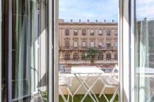 un balcón con mesa y sillas y un edificio en Apartment Ruzafa Zapadores, en Valencia