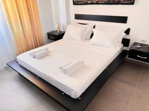 a bedroom with a bed with two towels on it at SoleMar Suites in Vlorë