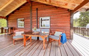 a wooden deck with a table and chairs on a cabin at Gorgeous Home In Gol With Sauna in Sanderstølen