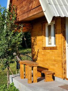 a picnic table and bench outside of a log cabin at Forest Cabin 3 in Žabljak