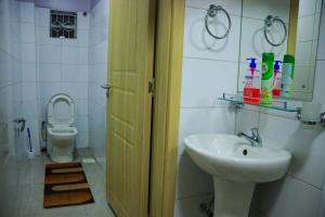 a bathroom with a sink and a toilet at Garden Maskan Villa in Gicheru +35 photos