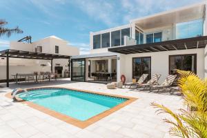 ein Haus mit einem Swimmingpool davor in der Unterkunft Villa María in Playa Blanca