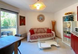 a living room with a couch and a table at Le Familial, Piscine Plage et Garage in Villeneuve-Loubet