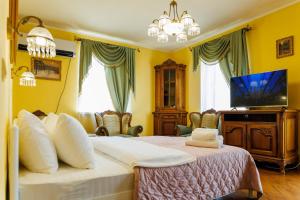 una camera con un grande letto e una TV di Квартира Антиквара у центрі Полтави Мережа AlexApartments Документи для відряджень Безконтатне заселення Цілодобово a Poltava Altre 30 foto