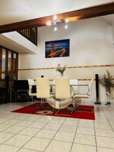 a room with a table and chairs and a piano at Belle maison confortable in Montfermeil