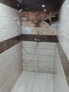 a shower with a hose in a white tiled bathroom at Стела 2 in Ruse +26 photos