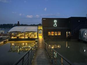 LedineKAME HOTEL BELGRADE,贝尔格莱德凯美酒店的水体旁的一座有码头的建筑