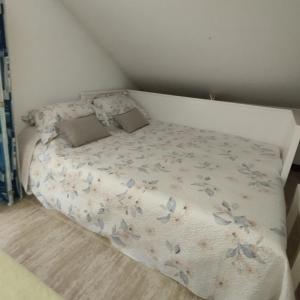 a small bed in a small bedroom with a bedspread with butterflies at Atico en Ajo Cantabria in Ajo