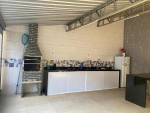 a large kitchen with white cabinets in a room at Casa Ubatuba in Ubatuba