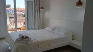 a white bedroom with a bed with towels on it at Afytos Dream suites sea view in Afitos