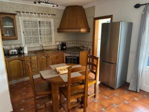 a kitchen with a table and a stainless steel refrigerator at Casa Cueva de los Verdes in Punta Mujeres