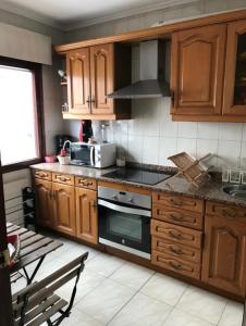 a kitchen with wooden cabinets and a stove top oven at Habitación Oviedo 2 in Oviedo