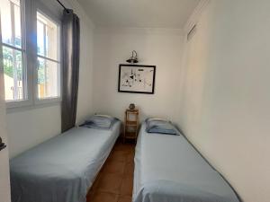 two twin beds in a room with a window at Les Restanques pressoir 3029 in Grimaud +39 photos