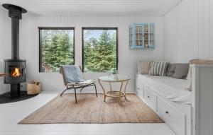 VejbyにあるLovely Home In Vejby With Kitchenのリビングルーム(ソファ、テーブル、暖炉付)