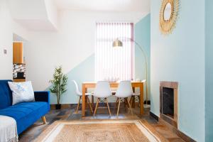 バロー・イン・ファーネスにあるEco-Friendly Home in Lake Districtのリビングルーム(青いソファ、テーブル、椅子付)