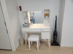 a desk with a mirror and a chair in a room at Haeundae Bada Residence in Busan