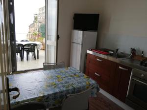 a small kitchen with a table and a refrigerator at La terrazza sul mare in Pizzo +17 photos