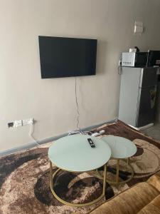 a living room with two tables and a flat screen tv at Tsavo studio in Nairobi